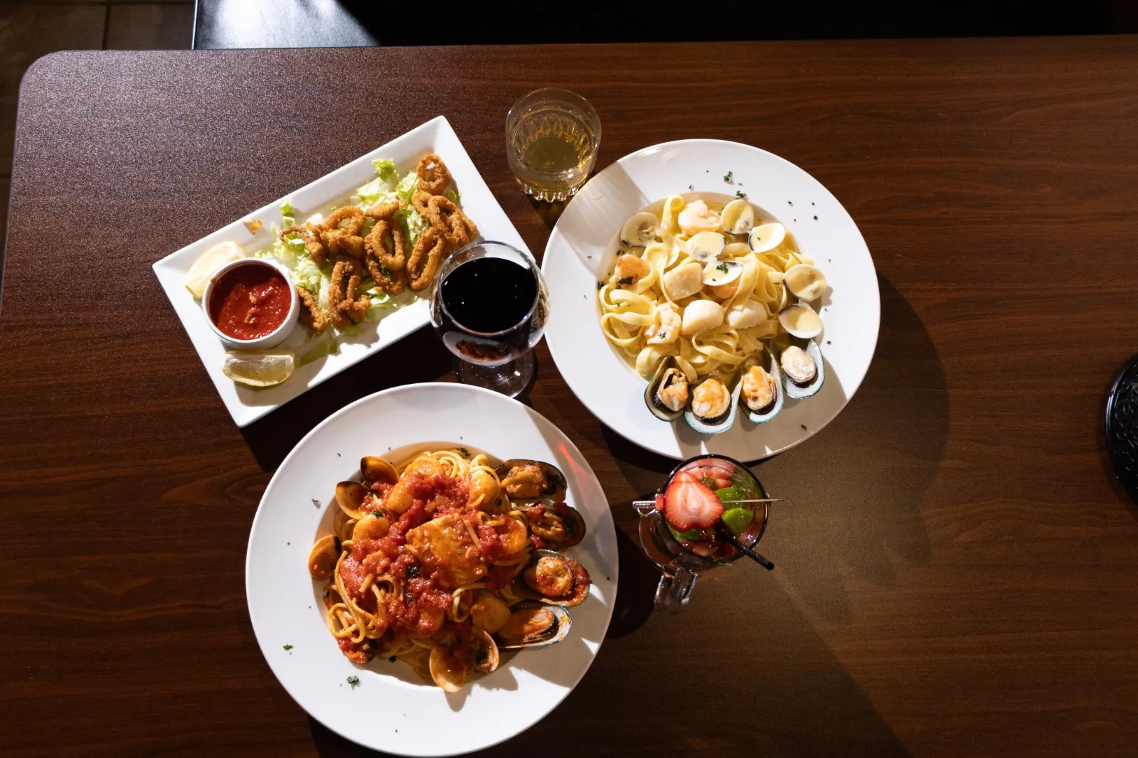 Calamari, shrimp scampi and seafood fra diavolo pasta plated at Bellini
