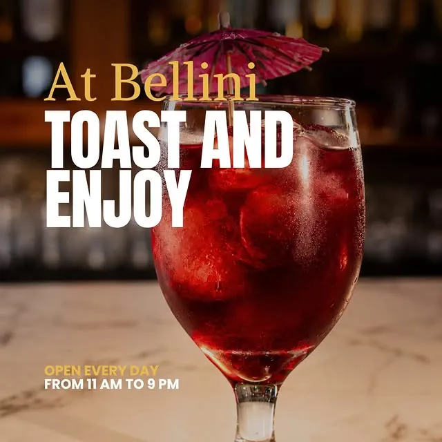 A red cocktail with a paper parasol on the marble bar