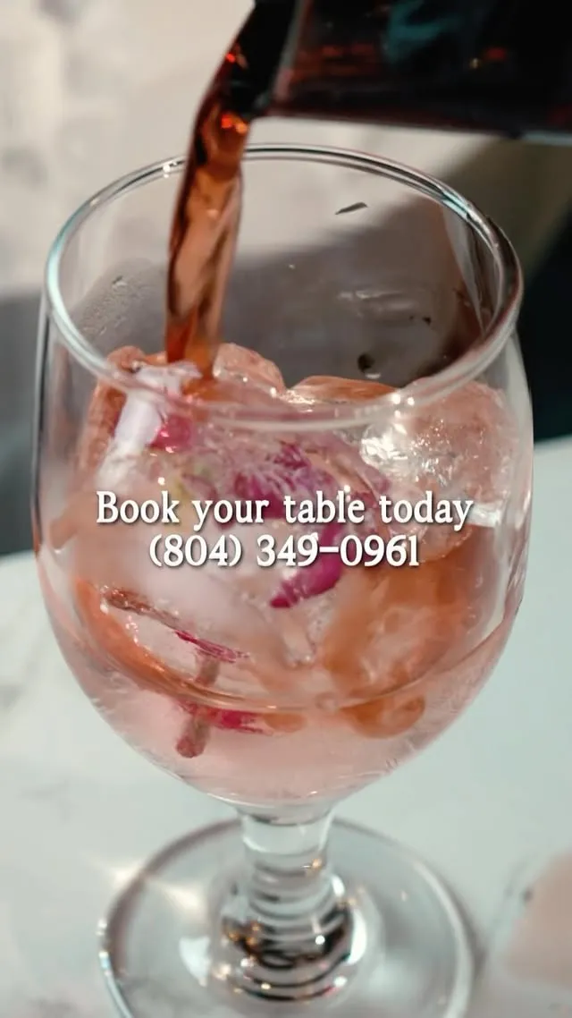 A rose petal cocktail being poured over ice