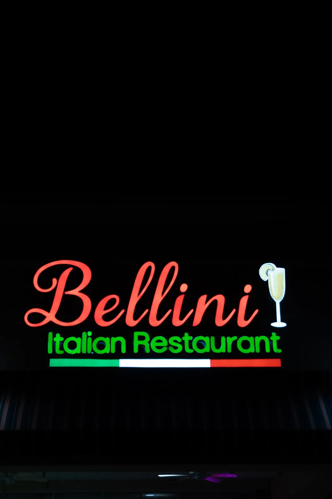 The illuminated Bellini Italian Restaurant sign at night